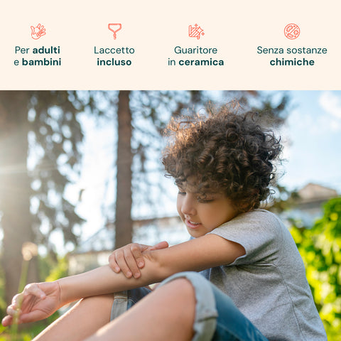 Bambino con capelli ricci utilizza dispositivo terapeutico Avilia sul braccio all'aperto, dimostrando l'uso sicuro per adulti e bambini con guaritore ceramico

